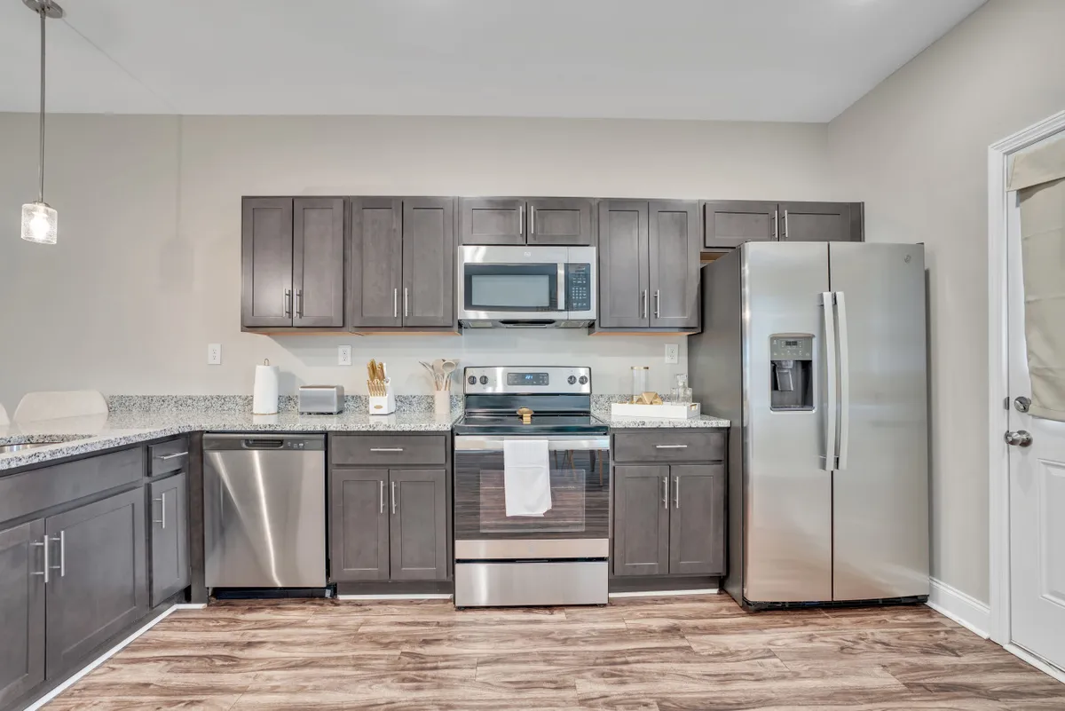 A modern kitchen featuring stainless steel appliances, sleek granite countertops, and rich dark cabinetry. The space is open and inviting, perfect for cooking, entertaining, and gathering with friends or family. The layout visually emphasizes both functionality and style, setting the stage for gourmet experiences or casual meals.